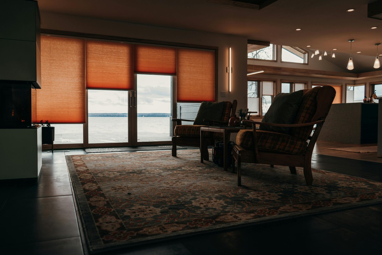 A warm, inviting living room showcasing classic furniture and a panoramic lake view.